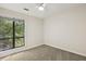 Bright bedroom featuring plush carpet, neutral paint, and a window offering a view of a verdant landscape at 120 Jo Anne Cir, Cary, NC 27513