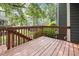 View of a stained wooden deck with a railing, overlooking a grassy lawn with other homes in the background at 120 Jo Anne Cir, Cary, NC 27513