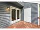 A gray, wood-sided building featuring an outdoor patio with weathered wood and a white door at 120 Jo Anne Cir, Cary, NC 27513