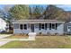 Charming single-story home featuring a light blue exterior, updated windows, and a well-maintained lawn at 1211 Freeman Dr, Sanford, NC 27330
