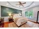 Serene bedroom with decorative wall, tray ceiling, hardwood floors, and natural light at 1216 Miracle Dr, Wake Forest, NC 27587