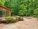 Expansive brick patio and backyard, surrounded by mature trees, perfect for outdoor enjoyment at 122 Blackcherry Ln, Chapel Hill, NC 27514