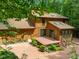 Charming home featuring a deck and brick patio, nestled within lush green landscape at 122 Blackcherry Ln, Chapel Hill, NC 27514
