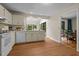 Bright kitchen featuring white cabinets, a view to the sunroom, and modern appliances at 122 Blackcherry Ln, Chapel Hill, NC 27514