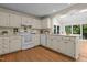 Well-lit kitchen with white cabinetry, modern appliances, and a breakfast bar overlooking a sunroom at 122 Blackcherry Ln, Chapel Hill, NC 27514