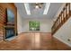 Bright living room featuring a fireplace, hardwood floors, large windows, and skylights at 122 Blackcherry Ln, Chapel Hill, NC 27514
