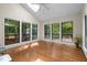 Bright sunroom with hardwood floors, a ceiling fan, skylight, and large windows offering scenic views at 122 Blackcherry Ln, Chapel Hill, NC 27514