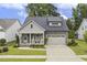 Charming home with two rocking chairs on the front porch, well maintained lawn and an attached two car garage at 1374 Patriot Points Way, Fuquay Varina, NC 27526