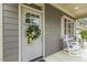 Charming front door with decorative wreath, sidelight and shuttered window at 1374 Patriot Points Way, Fuquay Varina, NC 27526