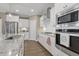 Modern kitchen featuring stainless steel appliances, granite countertops, and stylish white cabinetry at 1374 Patriot Points Way, Fuquay Varina, NC 27526