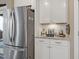 Coffee bar area featuring granite countertops, stainless steel refrigerator, and white cabinetry at 1374 Patriot Points Way, Fuquay Varina, NC 27526