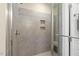Close up of tiled walk-in shower with built-in shelves and glass door at 1374 Patriot Points Way, Fuquay Varina, NC 27526