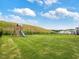 Spacious backyard with green grass, playground, and a black metal fence at 146 Bent Willow Dr, Clayton, NC 27527