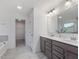Bright bathroom with dual sinks, gray cabinetry, and separate bathtub and walk-in closet at 146 Bent Willow Dr, Clayton, NC 27527