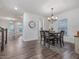 Open-concept dining area with hardwood floors and modern light fixture at 146 Bent Willow Dr, Clayton, NC 27527