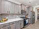 Kitchen featuring stainless steel appliances, gray cabinets, and quartz countertops at 146 Bent Willow Dr, Clayton, NC 27527