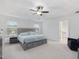 Large primary bedroom featuring tray ceiling, soft carpet, and ensuite bathroom entrance at 146 Bent Willow Dr, Clayton, NC 27527