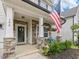 Inviting front porch with stone accents, a flag, and seating area at 146 Bent Willow Dr, Clayton, NC 27527