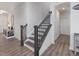 Bright entryway showcasing the staircase with dark wood steps and railing, and light grey wood flooring at 146 Bent Willow Dr, Clayton, NC 27527