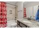 Full bathroom with a white countertop sink, tiled walls, and a vibrant Texas A&M shower curtain at 1508 Banks Brooke Dr, Raleigh, NC 27603