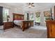 Spacious bedroom with plush carpet, ceiling fan, windows, and wooden furniture at 1508 Banks Brooke Dr, Raleigh, NC 27603