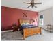 Cozy bedroom with a decorative red wall, a wooden bed, and a window bringing in natural light at 1508 Banks Brooke Dr, Raleigh, NC 27603