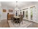 Bright dining room with hardwood floors, stylish chandelier, and adjacent doors leading to the porch at 1508 Banks Brooke Dr, Raleigh, NC 27603