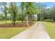 Long driveway leading to a two-story home surrounded by trees and greenery at 1508 Banks Brooke Dr, Raleigh, NC 27603