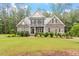 Charming two-story home featuring a stone facade, gray shingles, and lush landscaping at 1508 Banks Brooke Dr, Raleigh, NC 27603