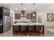 Stylish kitchen with stainless steel appliances, dark cabinetry, and a large central island with seating at 1508 Banks Brooke Dr, Raleigh, NC 27603
