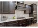 Modern kitchen features dark cabinets, stainless steel appliances, granite countertops and white tile backsplash at 1508 Banks Brooke Dr, Raleigh, NC 27603