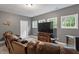 Cozy living room features a large TV, comfortable leather seating, and natural light from three windows at 1508 Banks Brooke Dr, Raleigh, NC 27603
