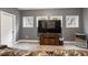 Comfortable living room with an entertainment center, a large TV, leather seating, and natural light from the windows at 1508 Banks Brooke Dr, Raleigh, NC 27603