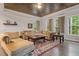 Cozy living room featuring a comfortable sectional sofa, hardwood floors, and plentiful natural light at 1508 Banks Brooke Dr, Raleigh, NC 27603