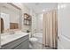 Modern bathroom with tile floors, gray vanity, decorative mirror, and combined shower and tub at 1533 Santa Lucia St, Wake Forest, NC 27587