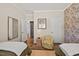 Comfortable bedroom with stylish wallpaper, two beds, chair, and access to other rooms at 1533 Santa Lucia St, Wake Forest, NC 27587