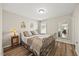 Comfortable bedroom with a metal frame bed, wood floors, natural lighting, and mirror at 1533 Santa Lucia St, Wake Forest, NC 27587