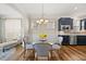Bright dining area features a glass table set, hardwood floors, and stylish blue cabinets at 1533 Santa Lucia St, Wake Forest, NC 27587