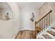 Inviting hallway featuring hardwood floors, staircase with wood banister and decorative wall art at 1533 Santa Lucia St, Wake Forest, NC 27587