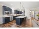 Stylish kitchen boasts navy cabinetry, stainless steel appliances, and a spacious island with seating at 1533 Santa Lucia St, Wake Forest, NC 27587
