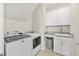 Well-equipped laundry room with modern appliances, granite countertop, cabinetry, and sink at 1533 Santa Lucia St, Wake Forest, NC 27587