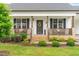 Charming front porch with decorative floral arrangements, complemented by lush landscaping and a welcoming entrance at 173 Longbow Dr, Middlesex, NC 27557