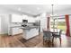 Modern kitchen with white cabinets, stainless steel appliances, dining area, and sliding glass doors to the backyard at 173 Longbow Dr, Middlesex, NC 27557