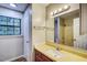 Well-lit bathroom featuring a vanity, sink, mirror, and a shower with tile surround at 2012 Stadium Dr, Durham, NC 27705