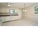 Bright kitchen featuring white appliances, tiled floors, and a cozy dining area with natural light at 2012 Stadium Dr, Durham, NC 27705