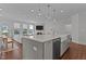 Open-concept kitchen with a large island featuring a farmhouse sink and a view of the living area at 2012 Sweet Samson St, Wake Forest, NC 27587