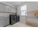 Modern laundry room featuring gray cabinets, granite countertops, and black stainless steel washer and dryer at 2012 Sweet Samson St, Wake Forest, NC 27587