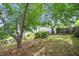 View of the wooded backyard with a privacy fence and partial view of the home at 202 Homestead Park Dr, Apex, NC 27502