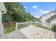 View of the backyard from the wooden deck with white railings and lush surrounding greenery at 202 Homestead Park Dr, Apex, NC 27502