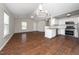 Spacious living room featuring wood floors, modern lighting, and an open layout to the kitchen at 202 Homestead Park Dr, Apex, NC 27502